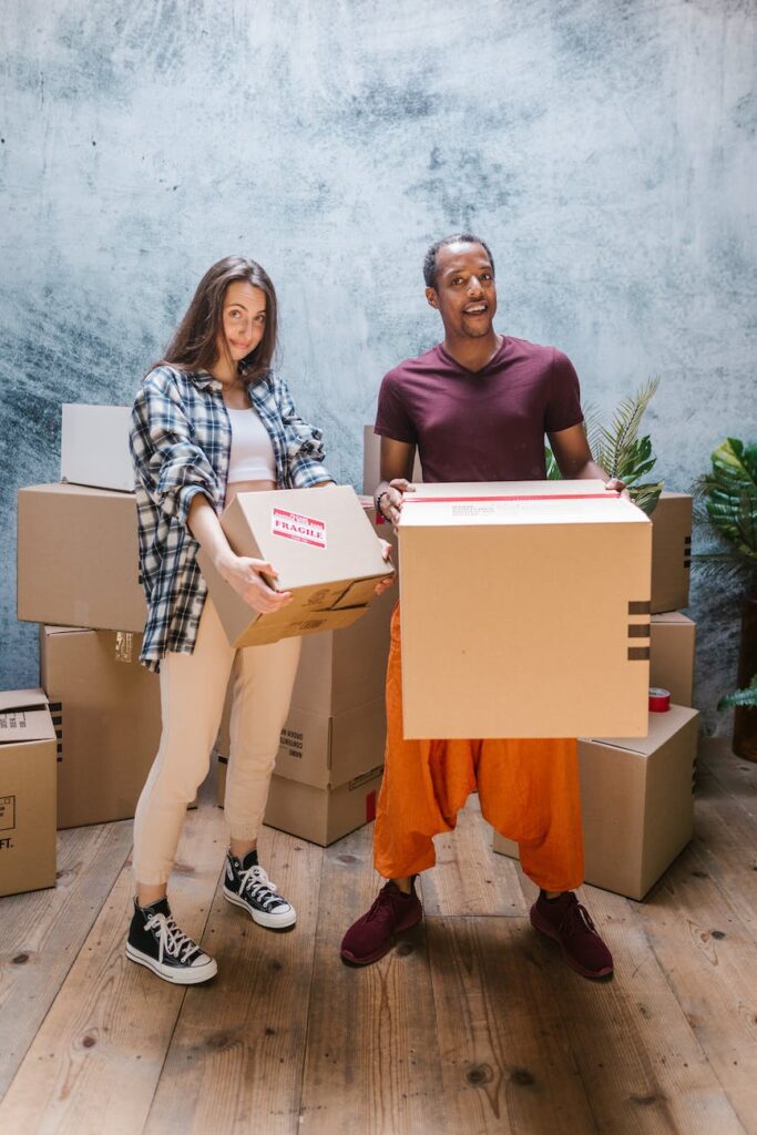 man and woman holding cardboard boxes